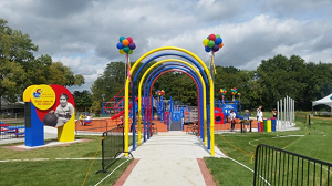 varicolored arches and balloons festoon the entrance to the ryan gray playground for all children