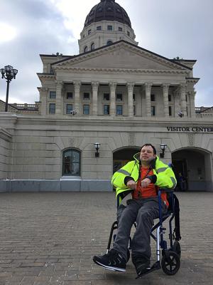 colin olenick, a wheelchair user, in front of the capital building in topeka