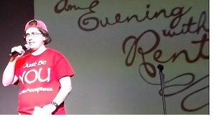 eb boresow does her standup comedy. she's wearing a red hat and t shirt