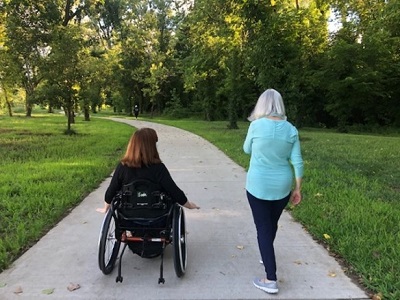 two women using a paved trail. one is a wheelchair user